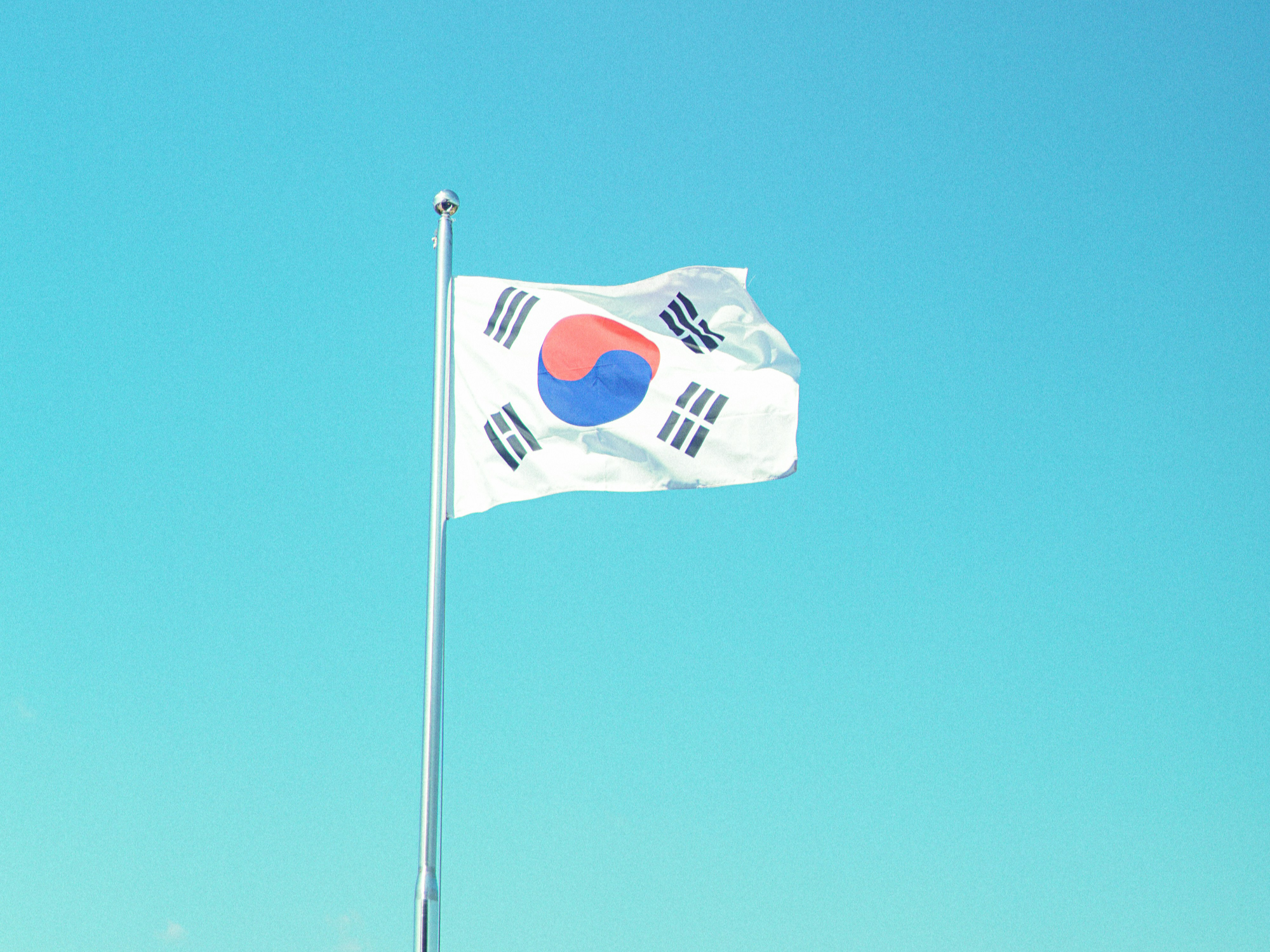 파란 하늘 아래 휘날리는 한국 국기 - 한미 자동차 관세 협정 분석