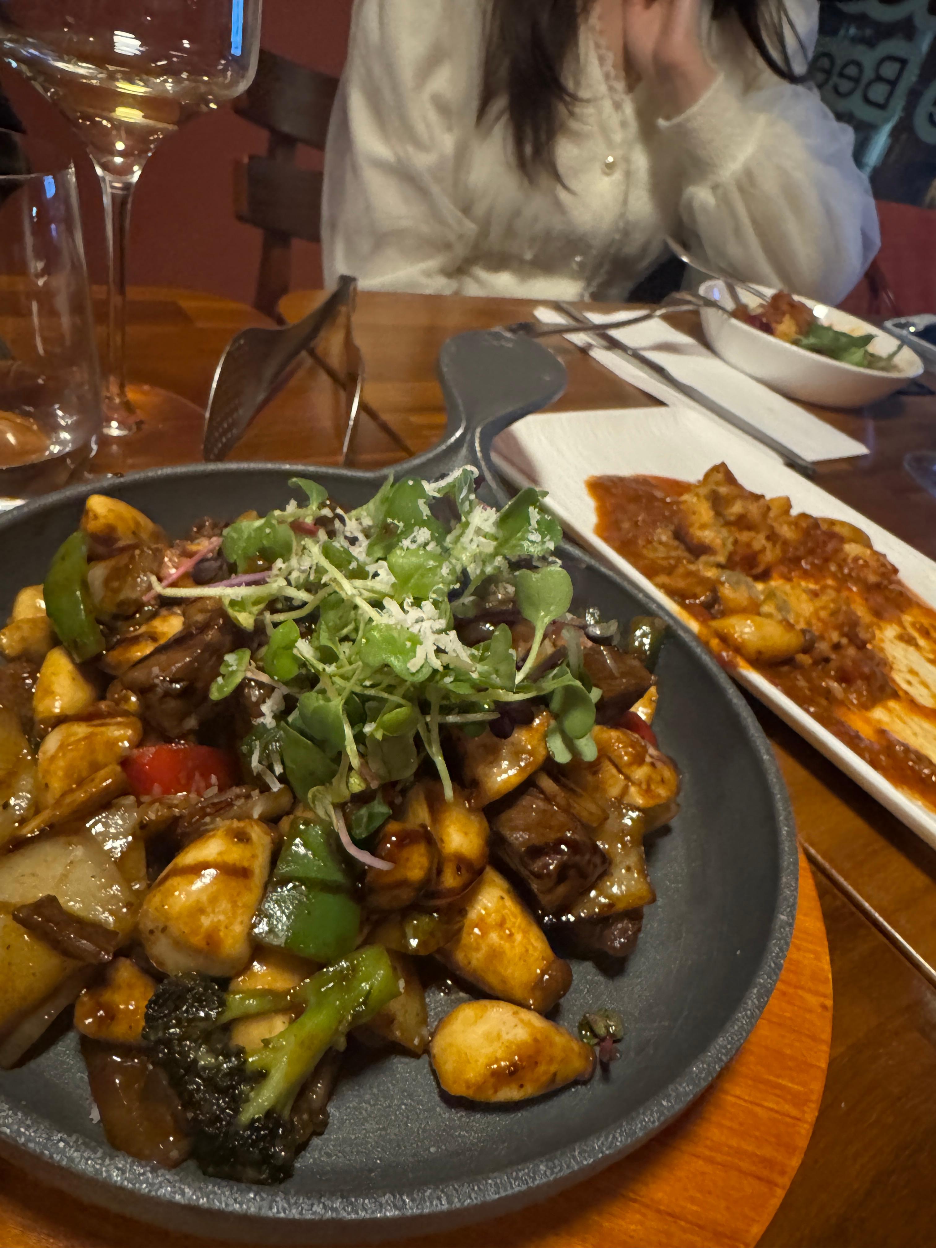 검은 팬에 담긴 찹스테이크&amp;#44; 소고기 큐브와 버섯&middot;브로콜리&middot;양파&middot;파프리카가 함께 볶아져 있고 위에 채소와 치즈가 올라간 요리