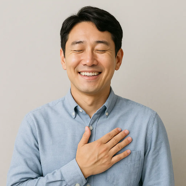가슴에 손을 얹고 눈을 감은 채 안도하며 웃는 청년 남성의 텍스트 없는 인물 이미지