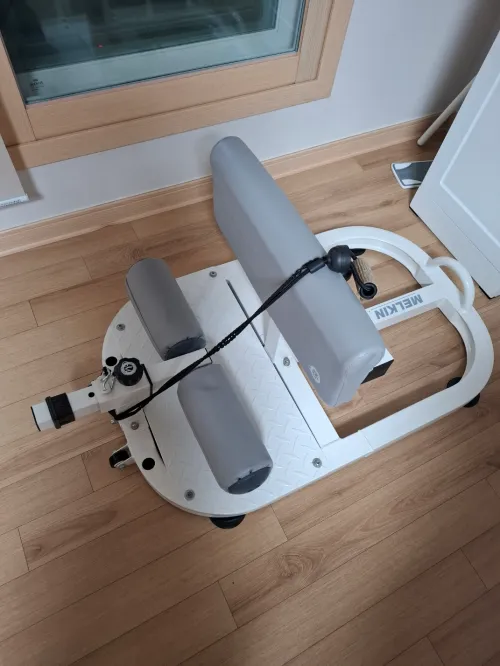 거실 한쪽에 놓인 사용자의 5분 루틴용 스쿼트 운동 기구 (The user's squat exercise equipment for a 5-minute routine placed in a corner of the living room)