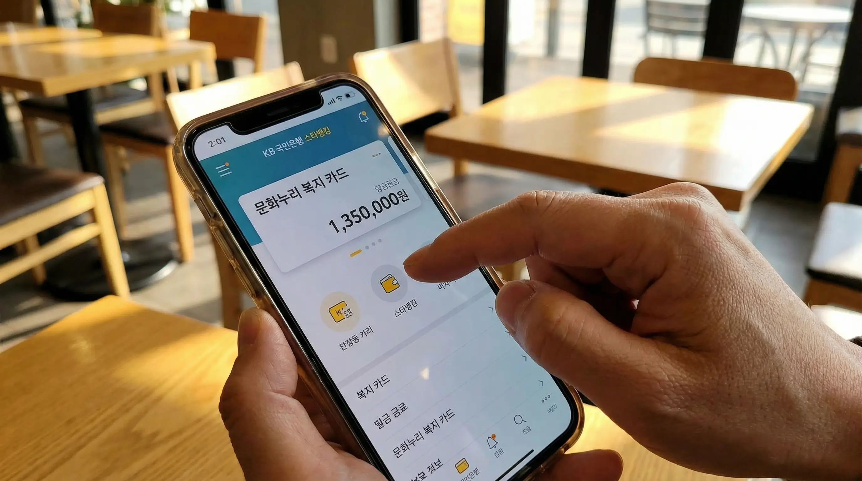 스마트폰 뱅킹 앱 화면에 문화 복지 카드 잔액이 표시되어 있고 손가락으로 확인하는 모습