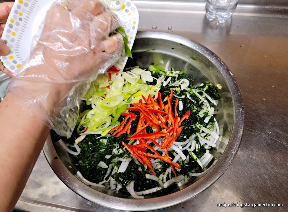 버무려진 파래 무침에 대파와 홍고추를 넣는 사진