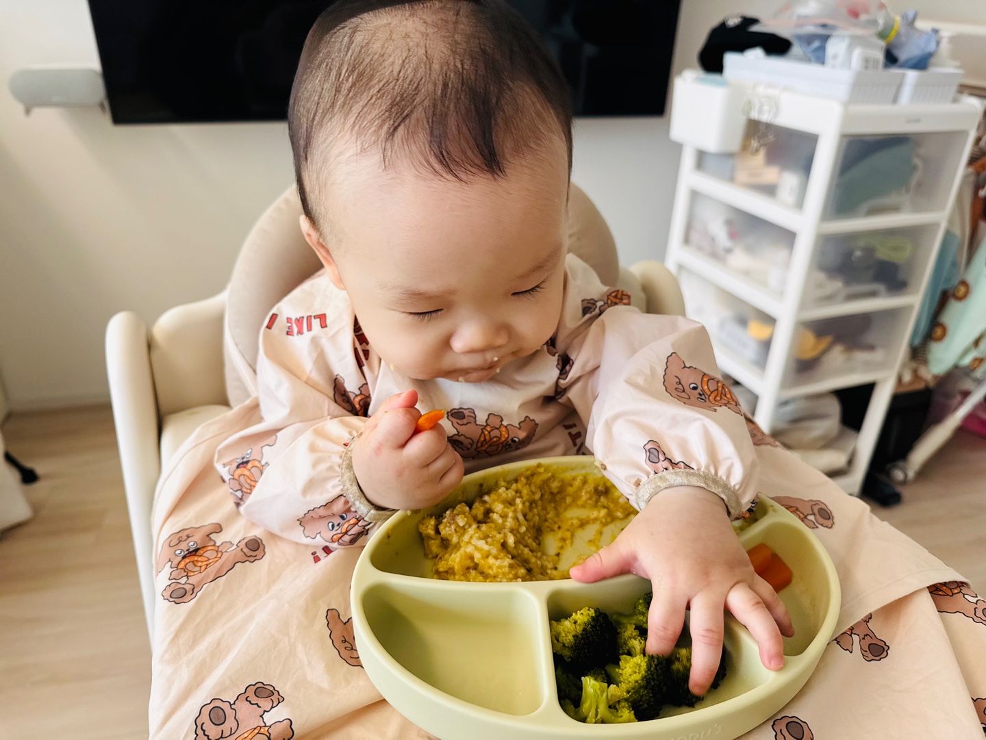 브로콜리를 향해 조심스레 손을 뻗으며 당근 스틱을 들고 있는 찬솔이의 점심 시간