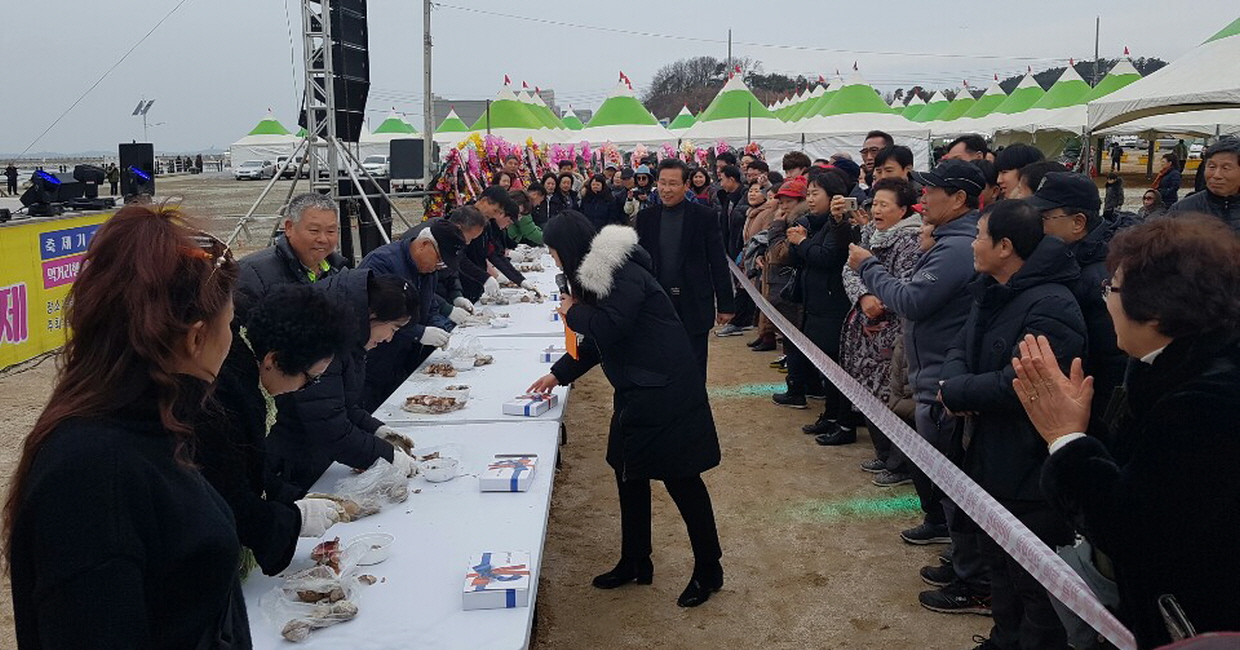 사람들이 새조개 체험과 축제를 즐기고 있다.