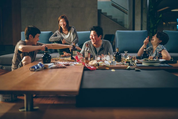 영화 《기생충》에서 반지하 가족이 부잣집 거실에서 주인 없는 파티를 즐기는 장면. 웃음과 술잔 사이로 계급과 욕망, 위태로운 경계가 스며든다.