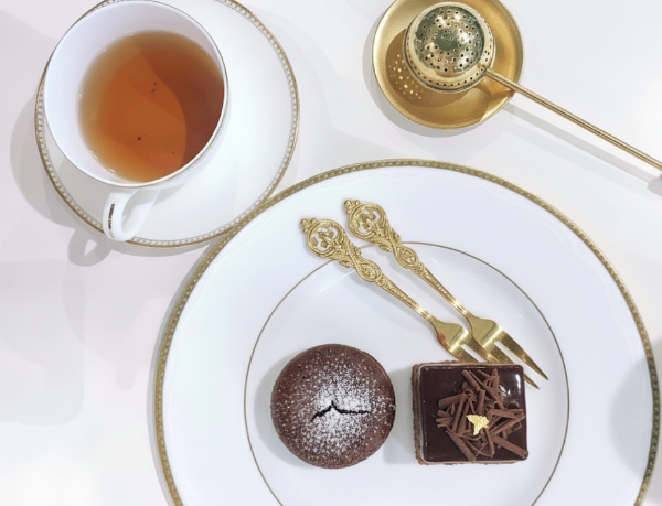 찻잔과 차 거름망 그리고 디저트가 담긴 접시.