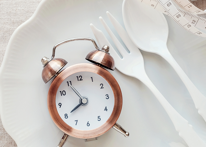 하얀 접시 위에 시계와 숟가락, 포크가 놓여져 있다