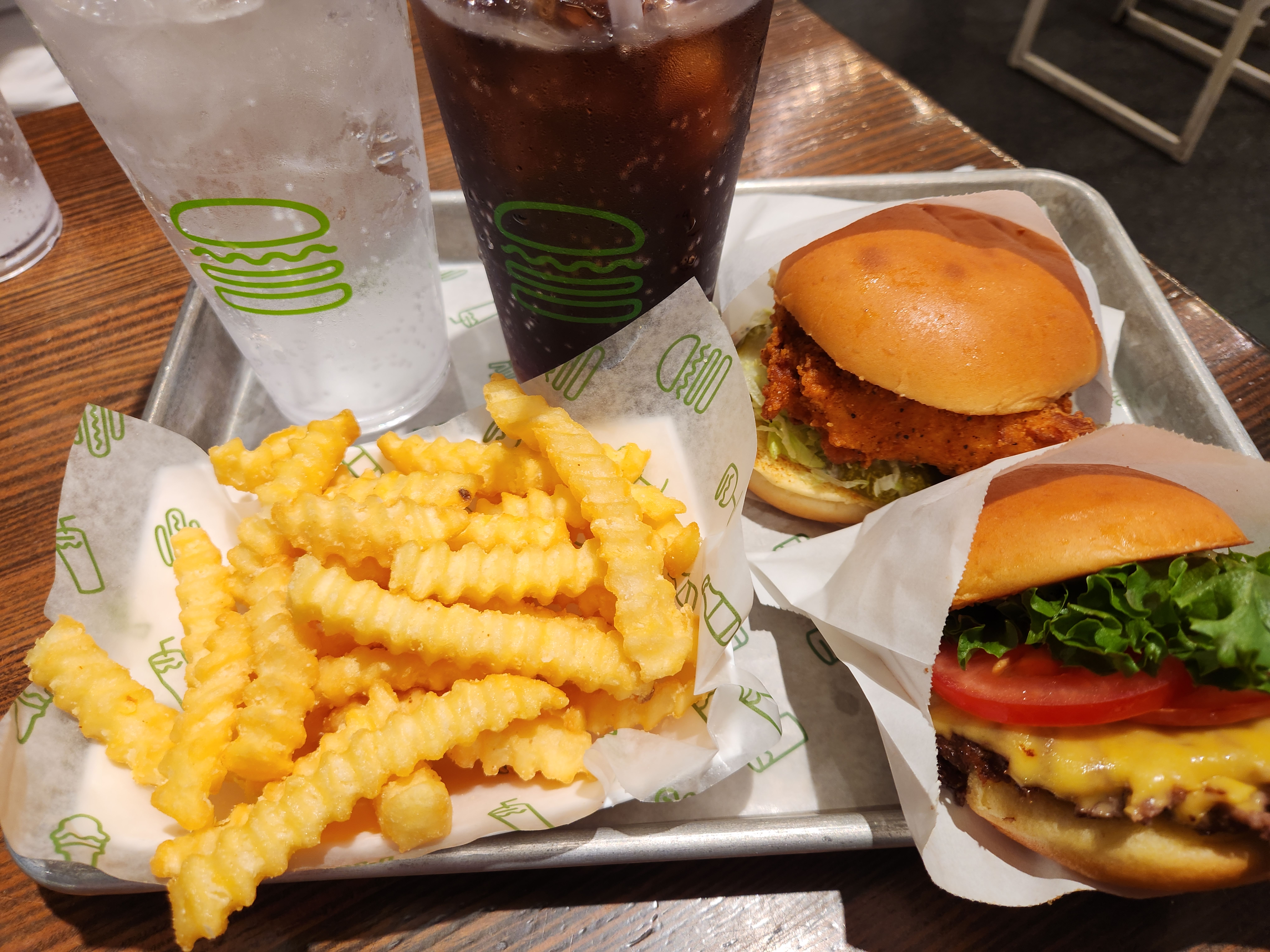 2 burgers, 2 cups of beverage are on the plate