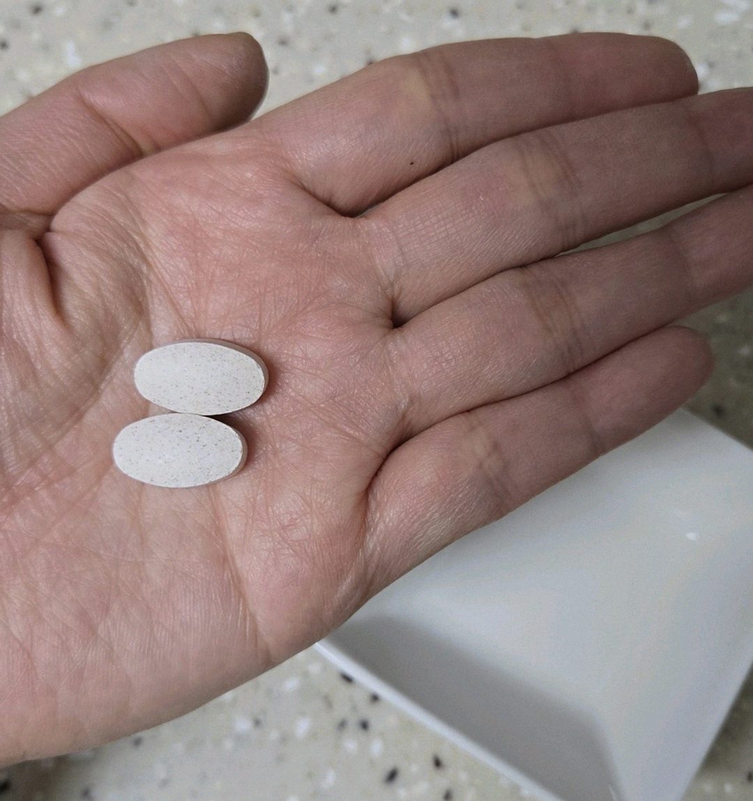 Korean Asian man in 40s taking supplement with breakfast