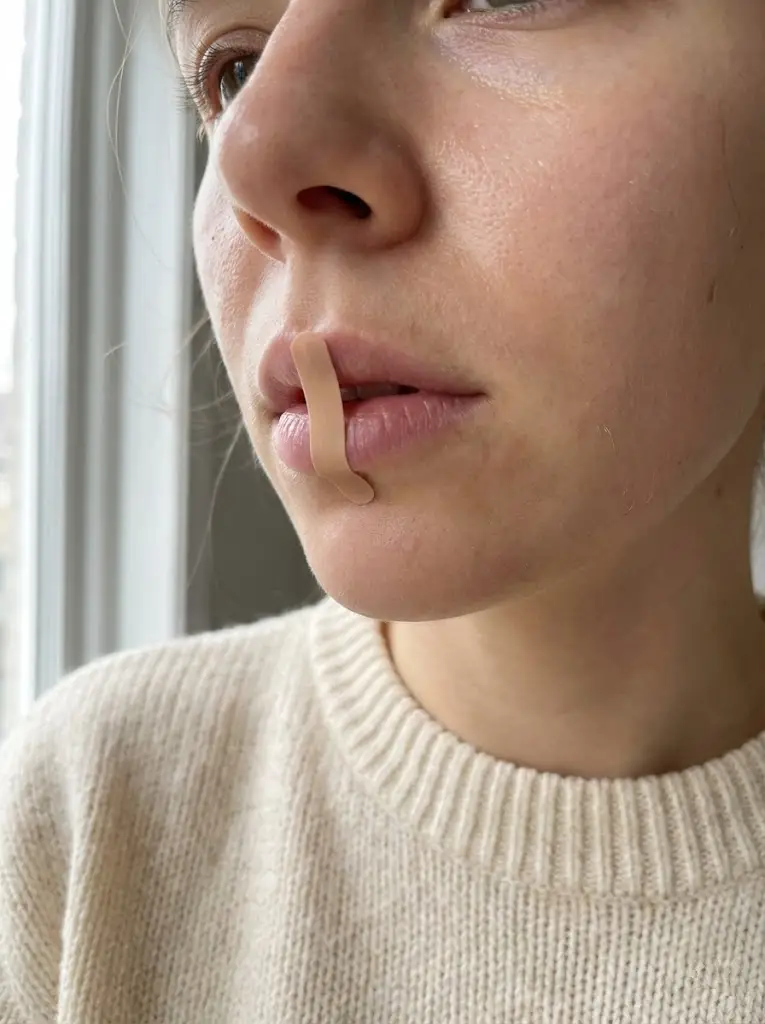 입술 중앙에 세로로 입 테이프를 붙이고 수면을 준비하는 모습