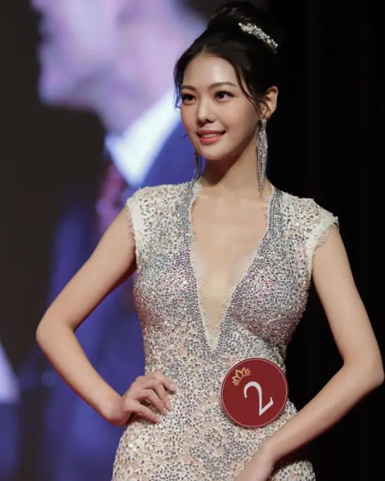 솔로지옥 3- 가슴이 깊게 파인 은색 민소매의 몸에 붙는 원피스를 입고 머리를 위로 올려묶은채 옆을 자신있게 바라보는 여자출연자 조민지