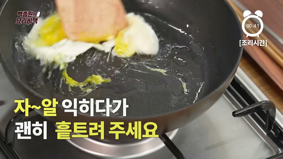프라이팬에서 달걀을 잘게 흩트려 볶는 장면