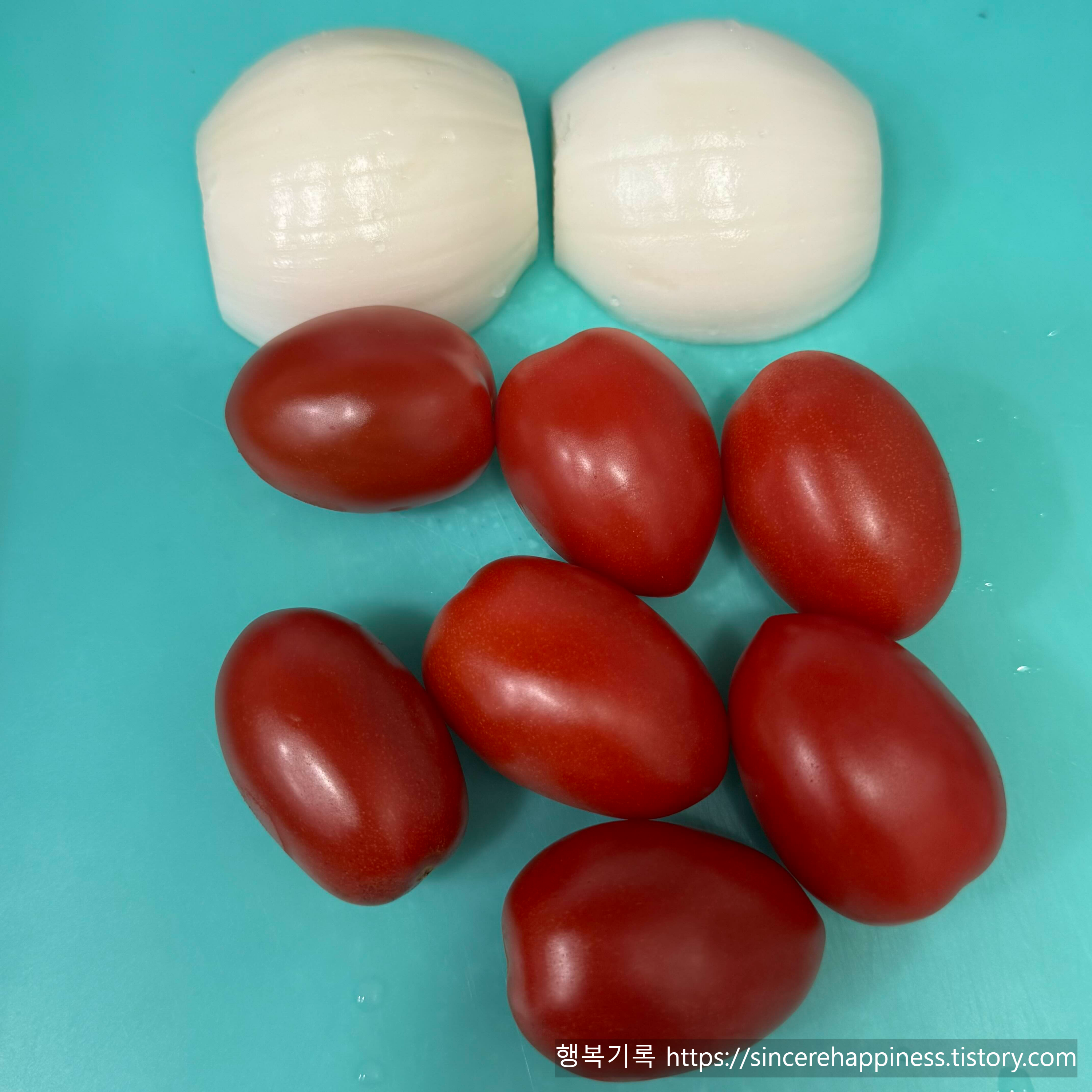 과카몰리 만들기 재료인 세척된 방울토마토 7개와 껍질 깐 양파 1개 준비