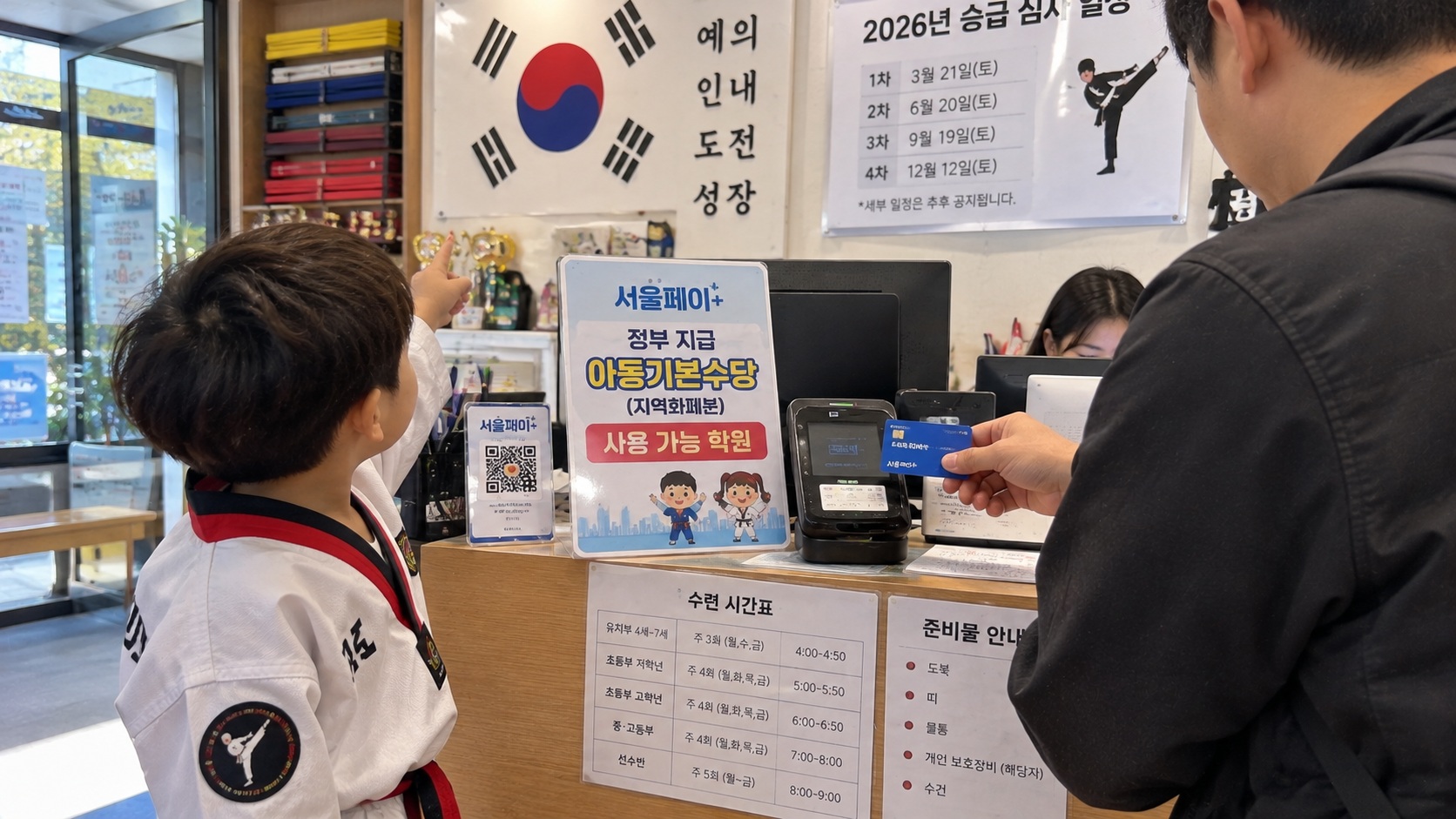 서울 태권도 학원 안내 데스크에서 아빠가 서울페이+ 결제 카드를 들고 학원비 결제를 준비하는 모습