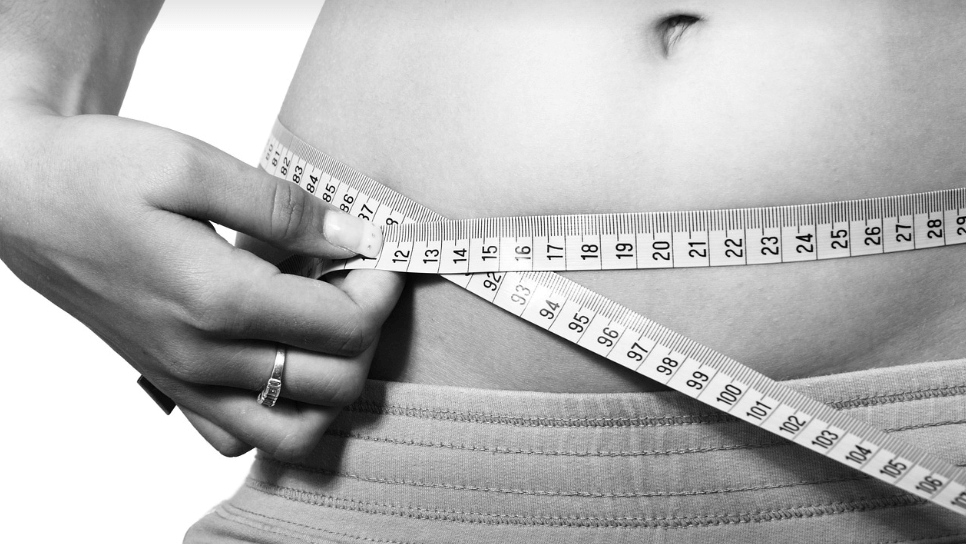 줄자로 여성이 허리를 잡고 있다