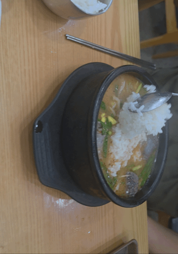 순댓국 뚝배기에 공깃밥을 말아 먹는 모습