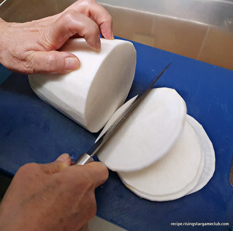 명절 나물국에 들어갈 무를 편으로 썰고 있는 사진