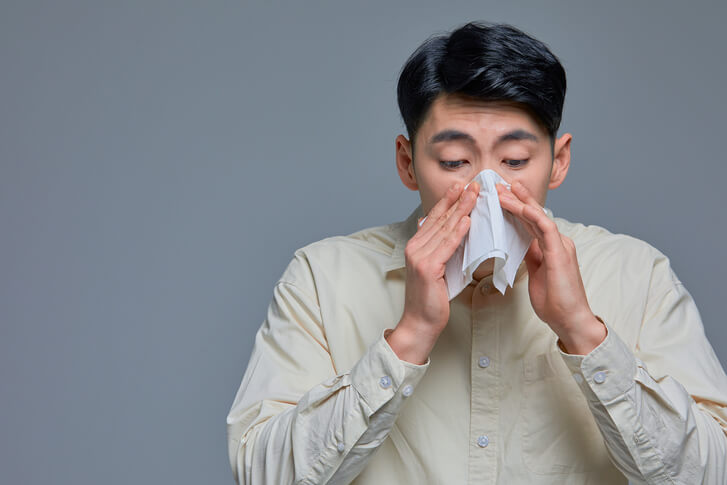 감기에 걸려 콧물을 닦는 남성