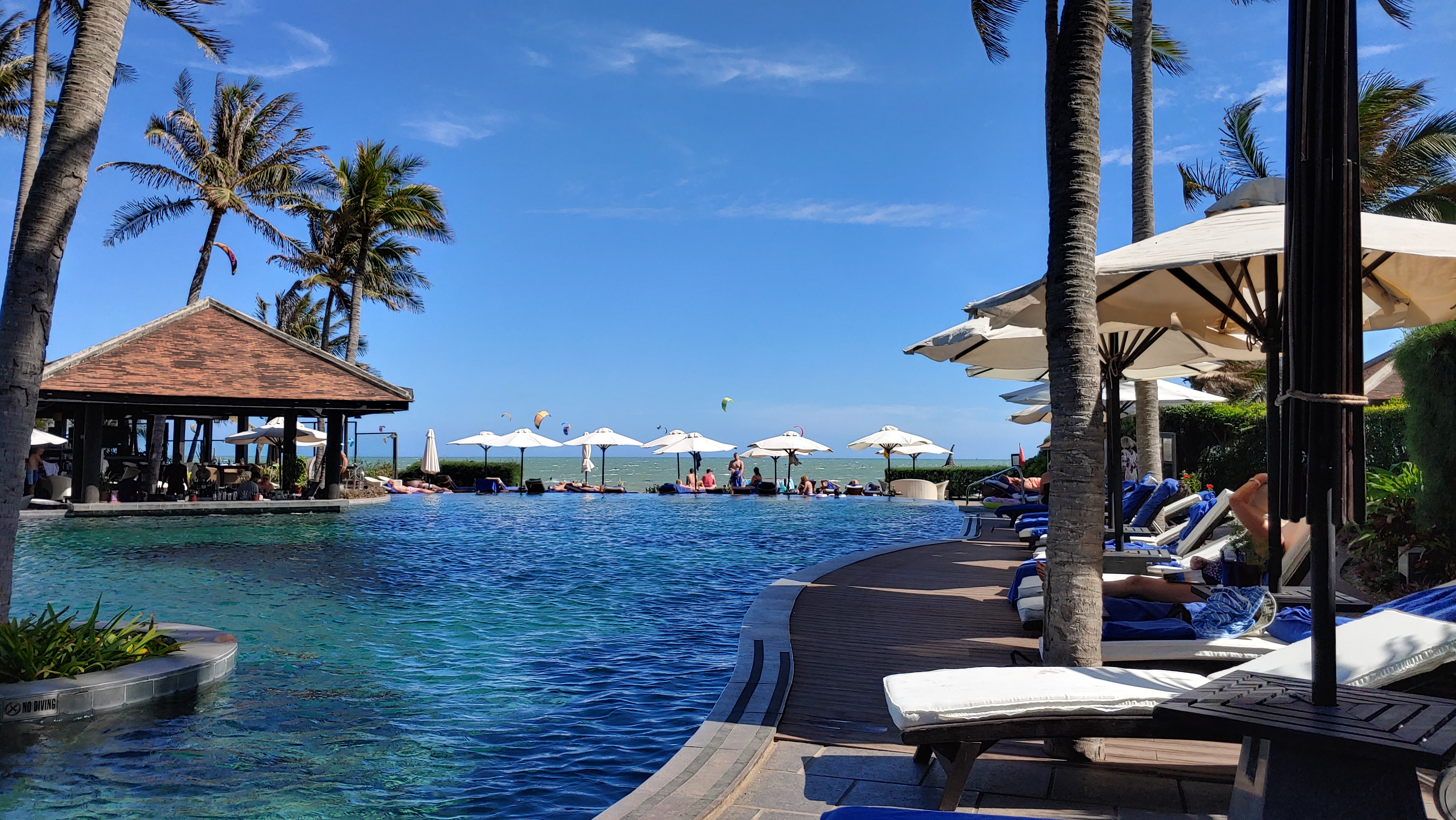 바다와 한라인에 있는 수영장. 바다에 위에서 해양스포츠를 하는 사람들