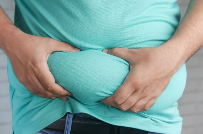 콜레스테롤이 쌓인 뱃살을 잡고 있는 모습
