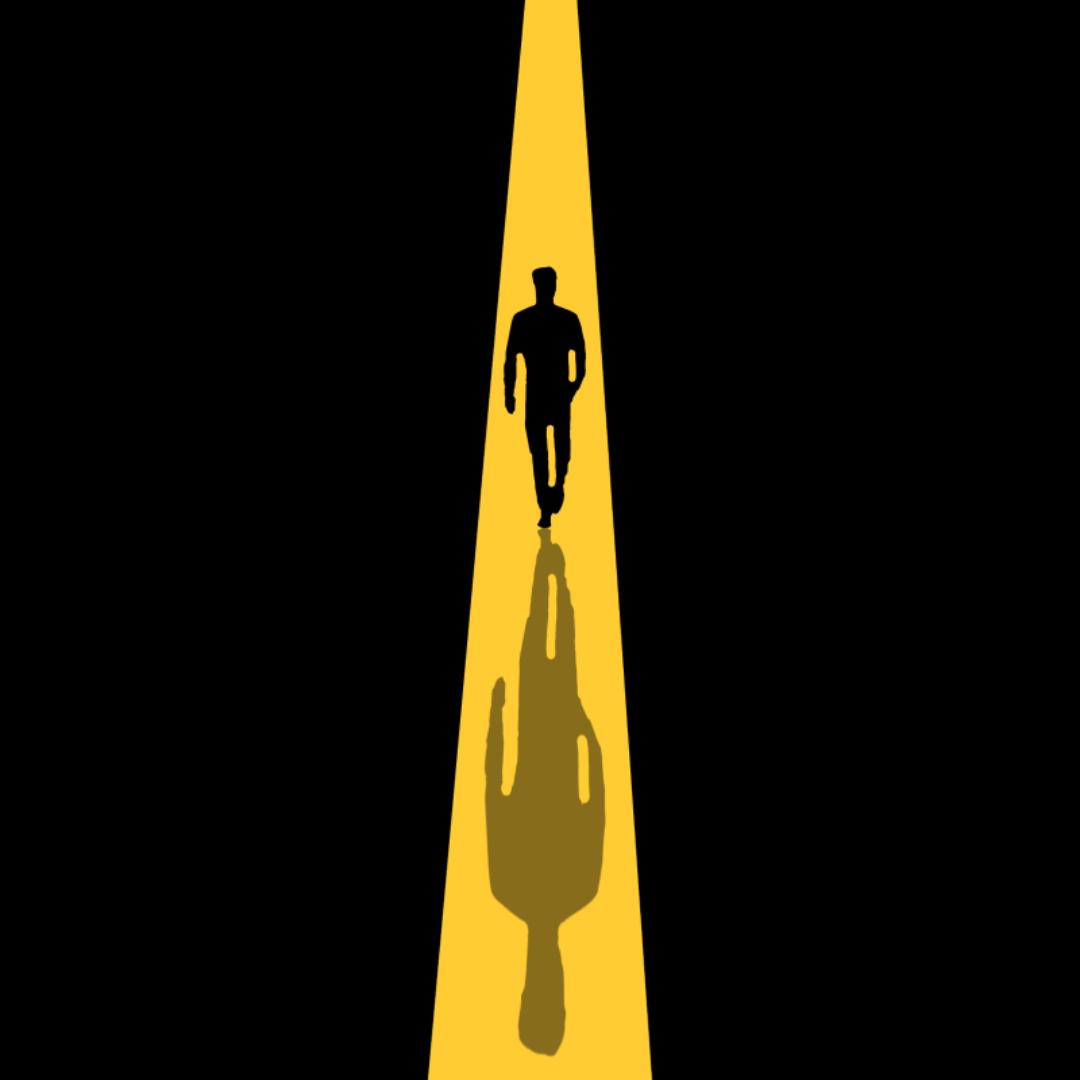 검은 배경에 한남자의 그림자 혼자 걷고 있다.