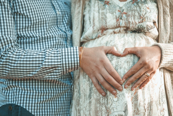 임신 중 역아 진단을 받은 산모와 배우자가 배 위에 손으로 하트 모양을 만들고 있는 모습, 역아 이해와 심리적 안정에 대한 이야기