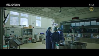 부검 중인 국가수와 이야기를 듣고 있는 형사들