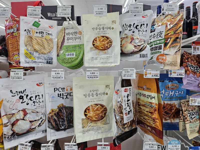 편의점 매장의 진열대에 오징어, 육포, 꾸이꾸이 등 다양한 마른안주 상품들이 정갈하게 진열되어 있는 모습