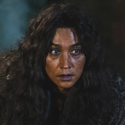 30대 남성이 긴 파마머리에 파란 눈동자를 하고 허름한 검은 옷을 입은 아라문의 검 아쓰루브