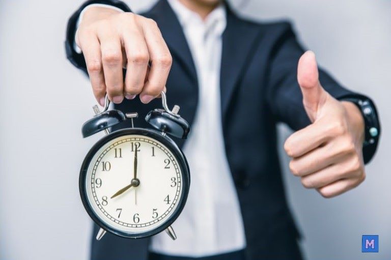 성공한 비즈니스맨이 알람시계를 들고 엄지손가락을 치켜세우며 시간 관리의 중요성을 보여주는 모습 via canva