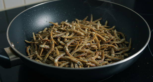 프라이팬에 잔멸치를 넣고 약불로 노릇하게 볶고 있는 모습