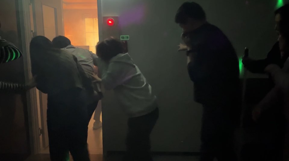 연기가 가득찬 공간에서 벽을 따라 몸을 숙이고 대피중인 모습