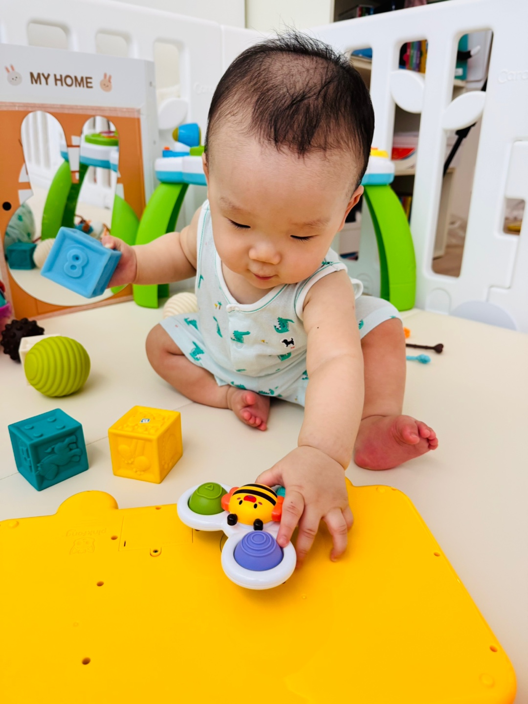 흡착 스피너 장난감을 손으로 돌리며 탐색하는 아기