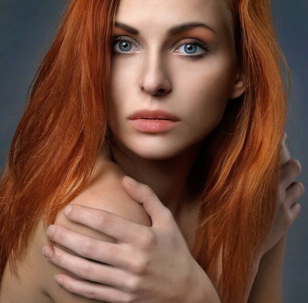 정면을 응시하고 있는 오렌지색 머리 색깔의 여성