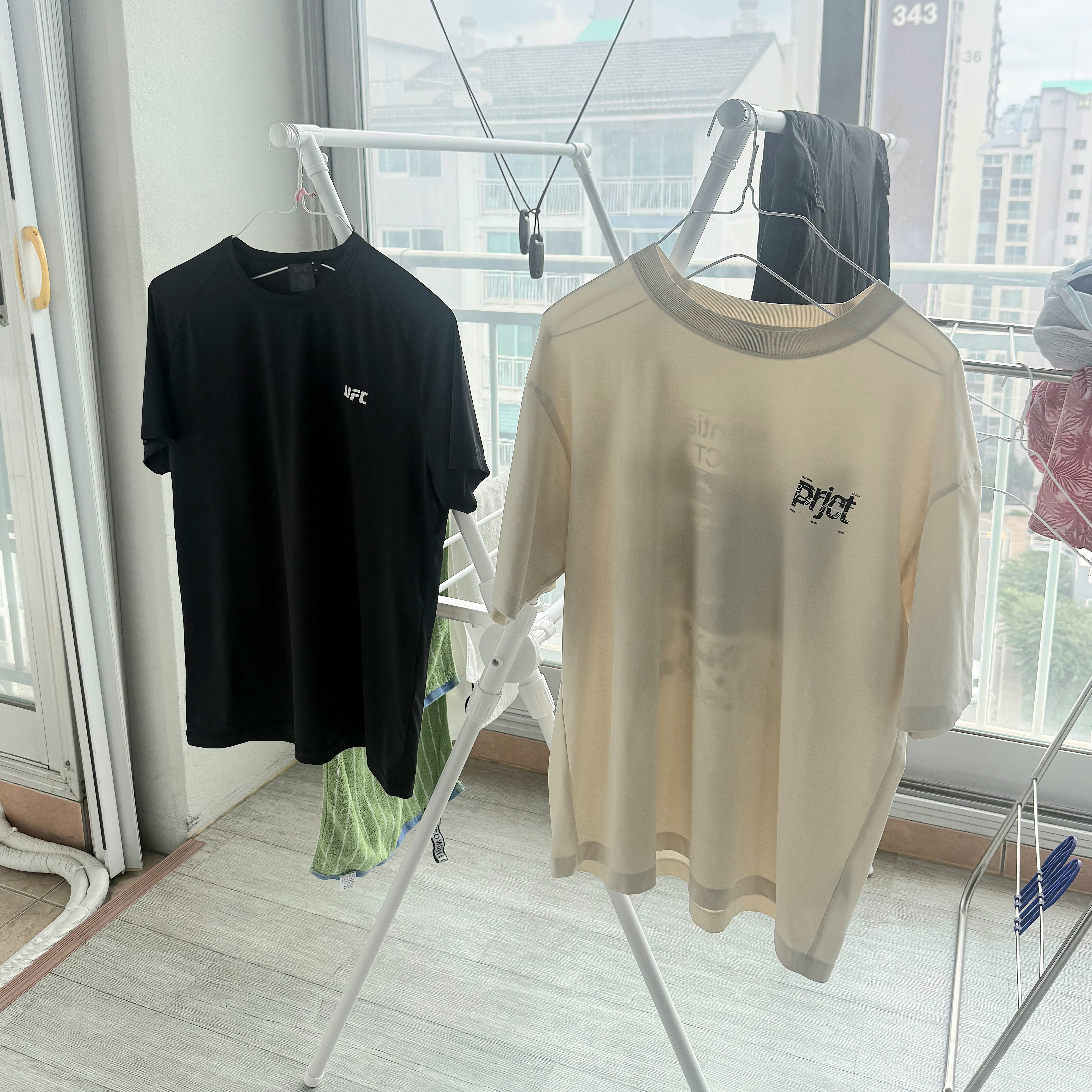 땀이 밴 티셔츠를 빨래통에 넣기 전 건조대에 잠시 펼쳐 말리는 모습