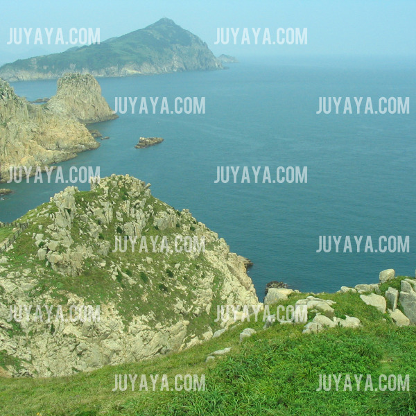 A scenic view of the rocky coastline of Somaemuldo Island, with lush greenery and the ocean stretching out into the horizon.