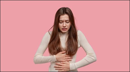 아랫배를 붙잡고 있는 여성