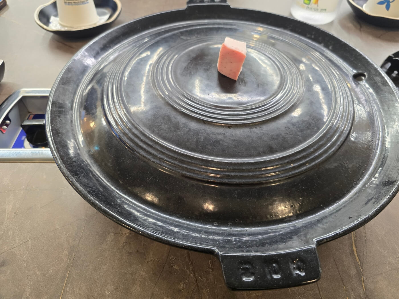 구이용 무쇠솟위에 올려진 돼지비계한점