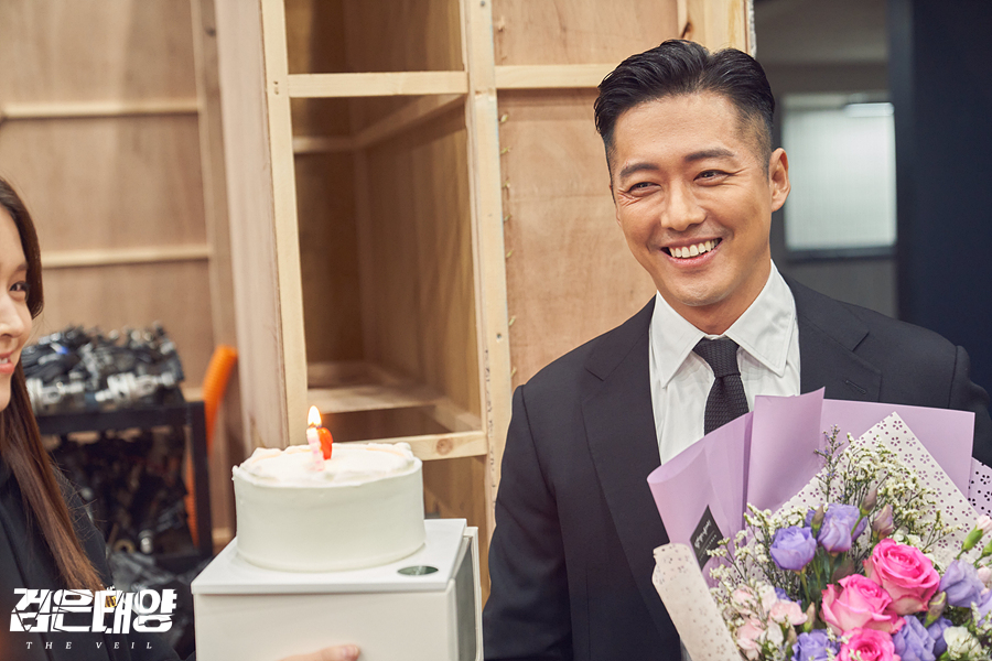 촬영 종료 현장에서 꽃다발을 들고 웃는 남궁민과 옆에 놓인 케이크