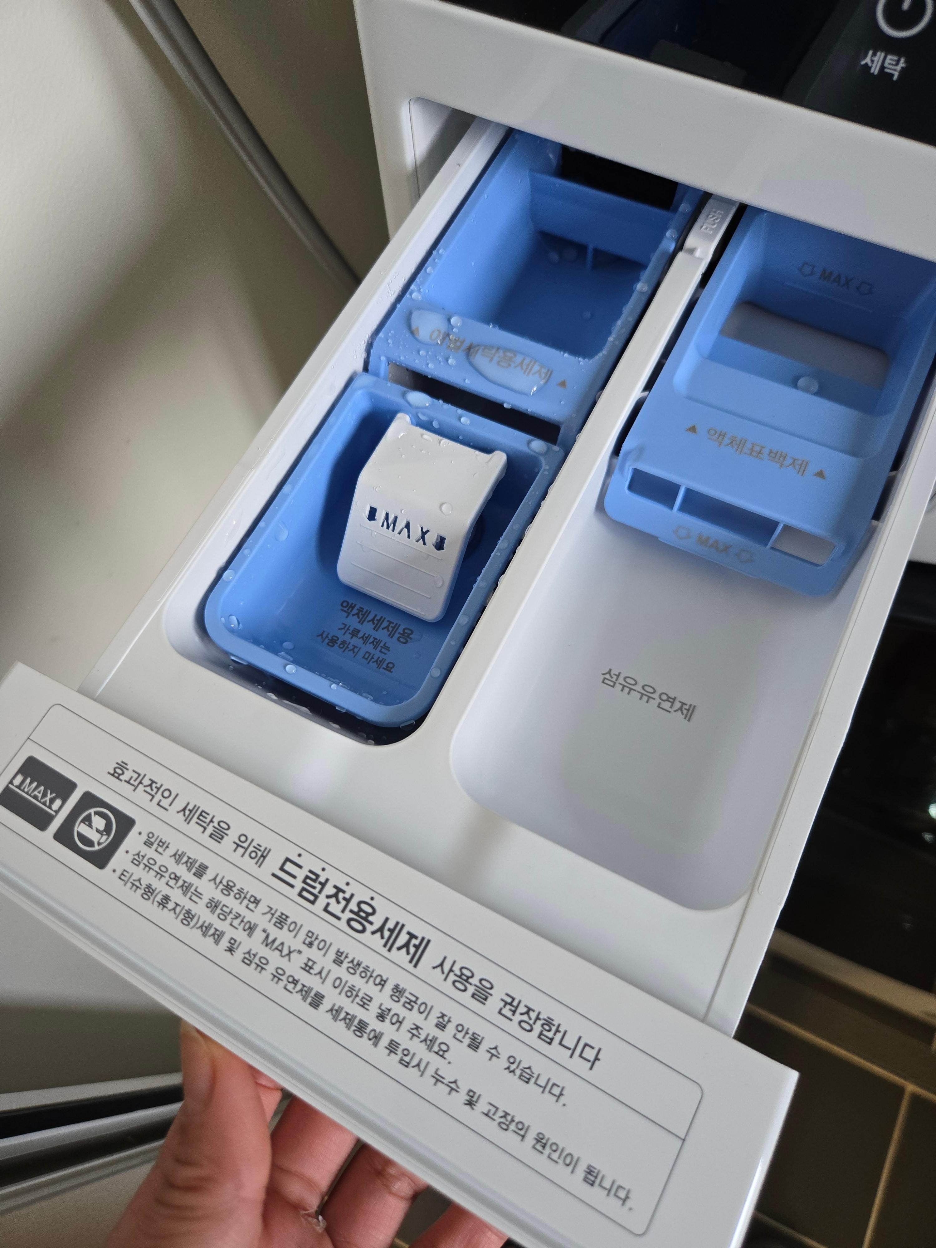 LG 워시타워의 세제 투입구를 열어 액체세제와 섬유유연제 칸이 보이는 모습