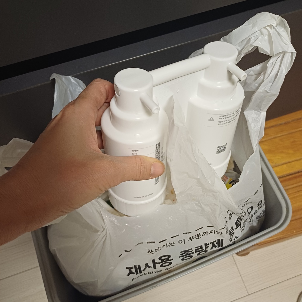 물기를 뺀 다 쓴 정수기 필터를 일반 종량제 봉투에 담는 모습