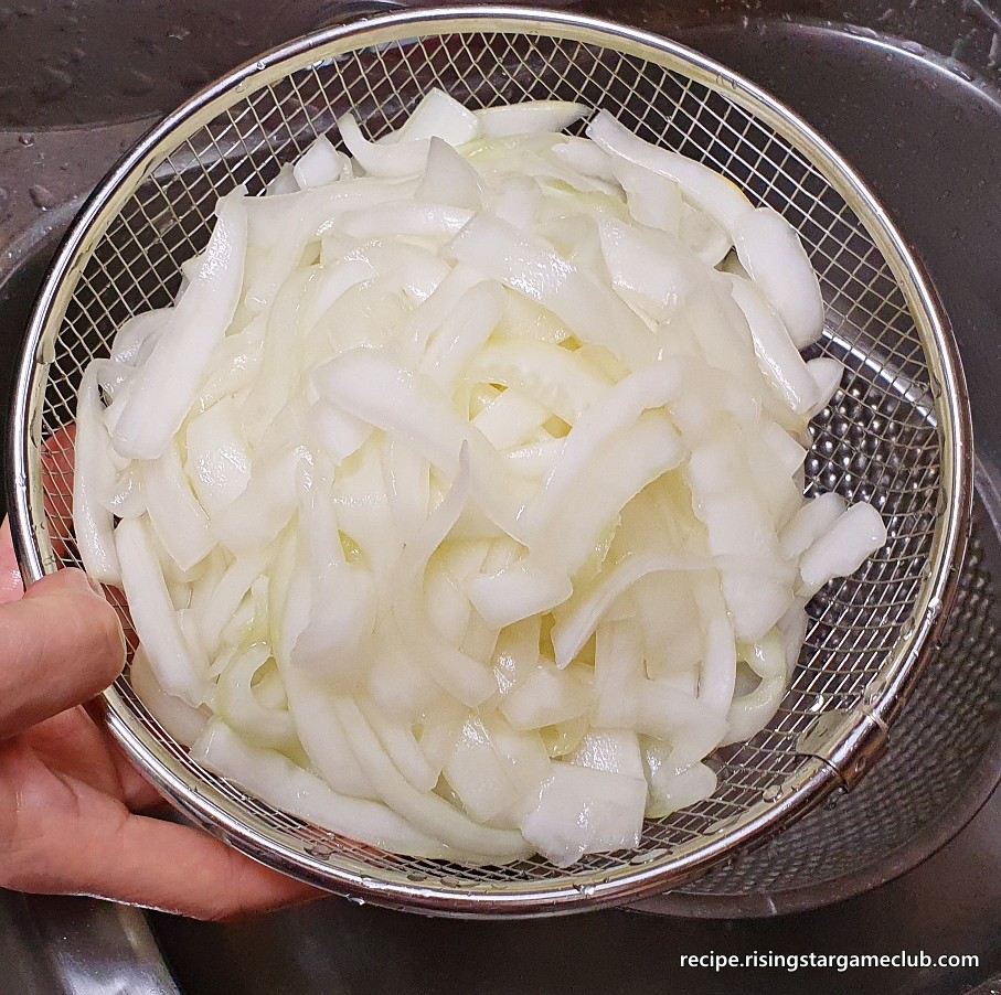 노각 무침을 하기 위해 흐르는 물에 씻은 절인 노각을 채반에 받쳐 주는 사진