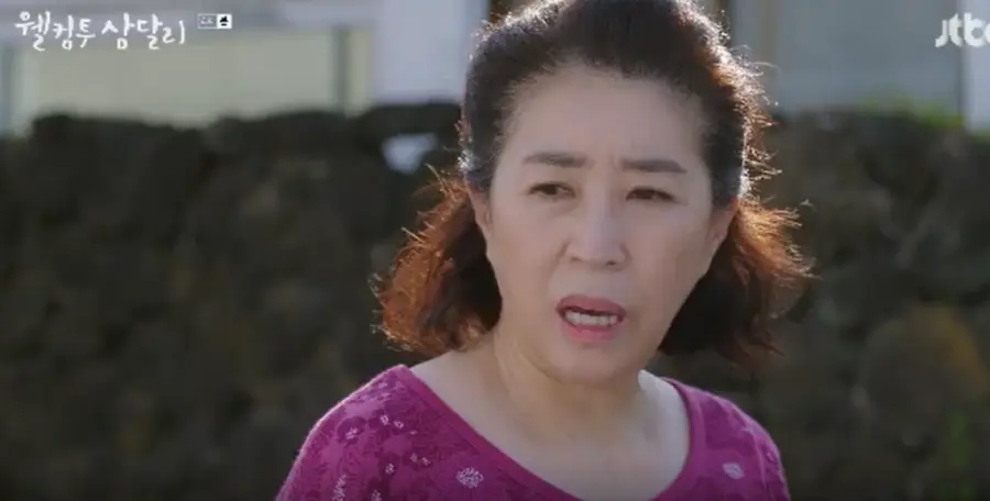 웰컴투삼달리- 보라색 옷을 입고 옆을 보며 말하고 있는 고미자