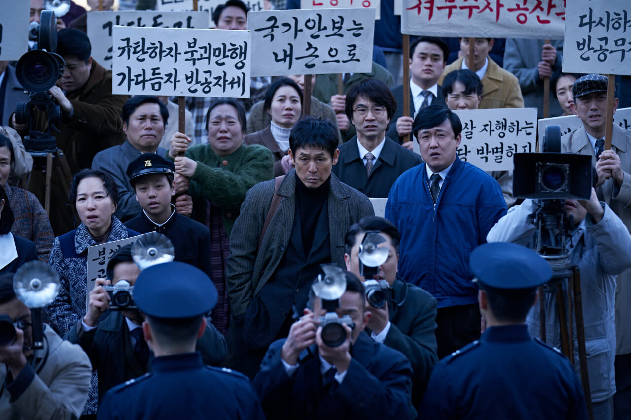 뉴스를 만들어 내는 아무개가 기자들과 국민들 가운데 서있는 모습