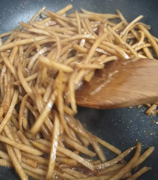 양념을 넣어 우엉을 볶고 있는 모습