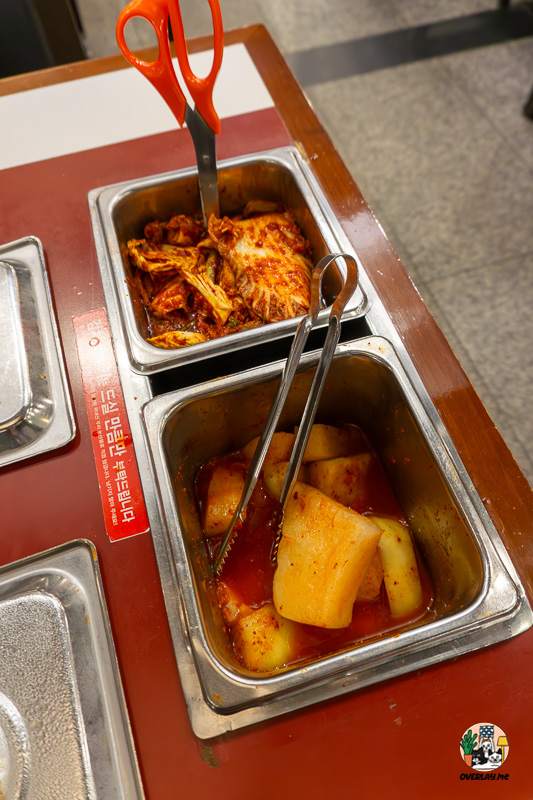 명가원 설농탕의 김치·깍두기 셀프바. 가위와 집게가 놓여 있고, 김치와 깍두기가 신선하게 보관되어 있다.