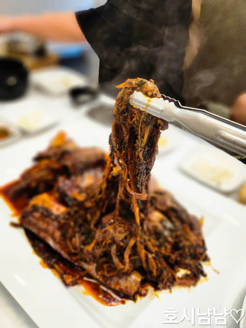 코다리덕장 코다리조림 근접샷, 집게로 시래기 들어 올린 장면