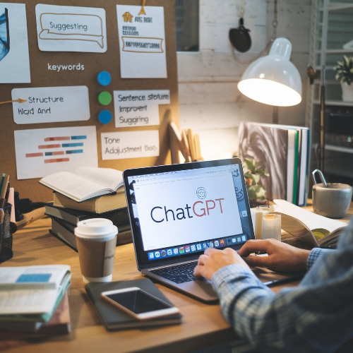 책상 위에 키워드가 적힌 노트와 ChatGPT 텍스트가 보이는 노트북 화면