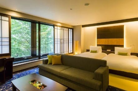 노란빛이 감도는 전등을 사용한 실내 객실사진 침대와 소파등이 놓여져 있다.