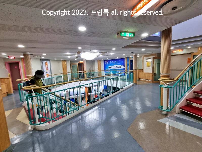 가운데 계단을 내려가는 한사람과 밑에 많은 사람이 모여있다.